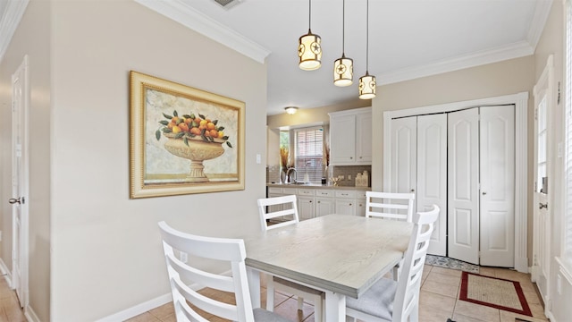 dining area featuring ornamental molding, light tile patterned floors, and baseboards