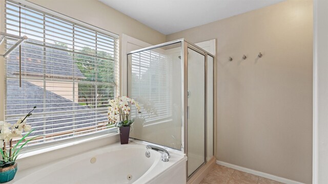 bathroom featuring a shower stall, a whirlpool tub, tile patterned floors, and baseboards