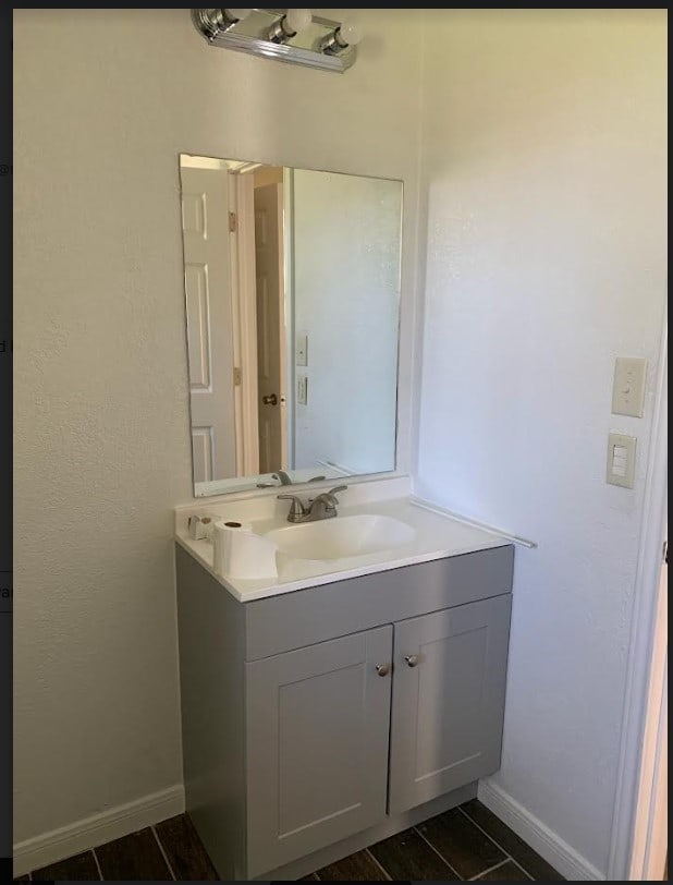 bathroom featuring baseboards, tile patterned floors, and vanity