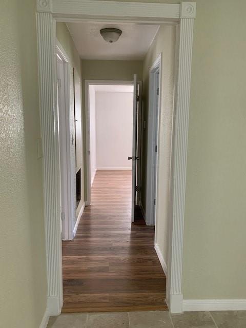 hall featuring baseboards and wood finished floors
