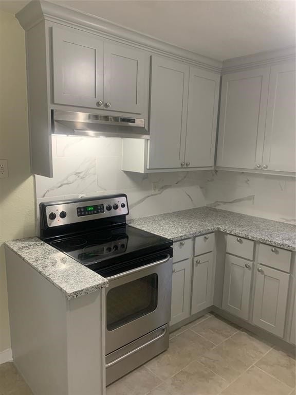 kitchen with gray cabinets, under cabinet range hood, light stone countertops, and stainless steel electric range oven