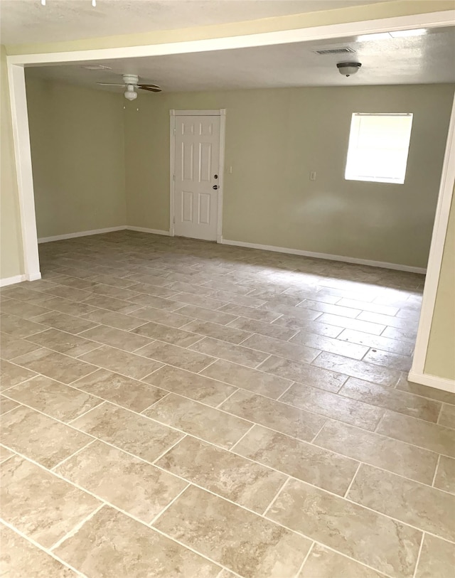 unfurnished room featuring baseboards, a ceiling fan, and visible vents