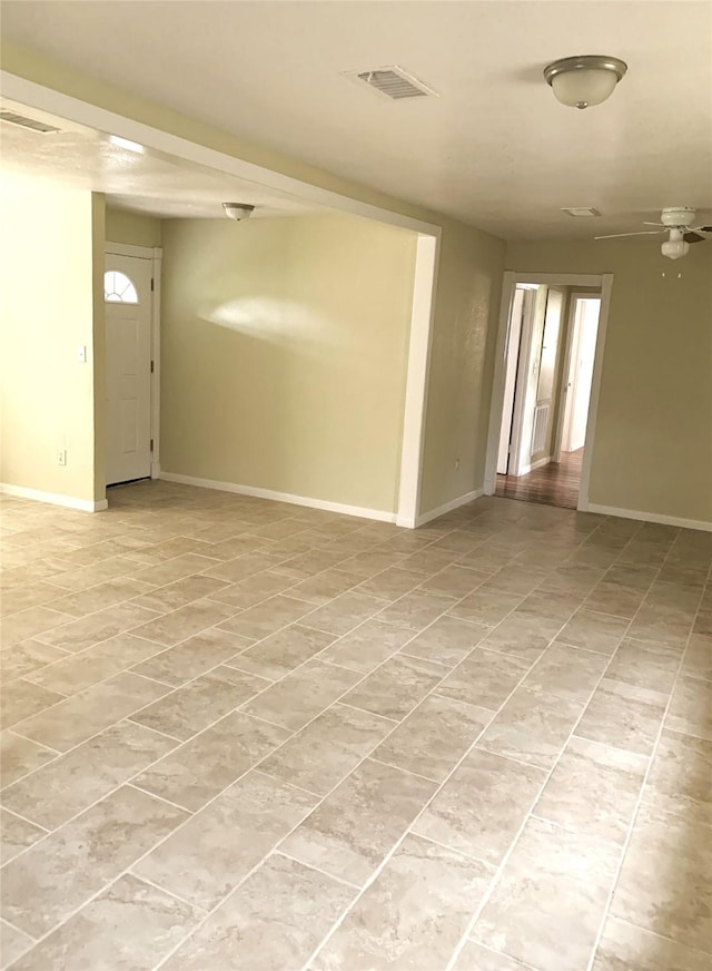 unfurnished room featuring baseboards, light tile patterned flooring, and visible vents