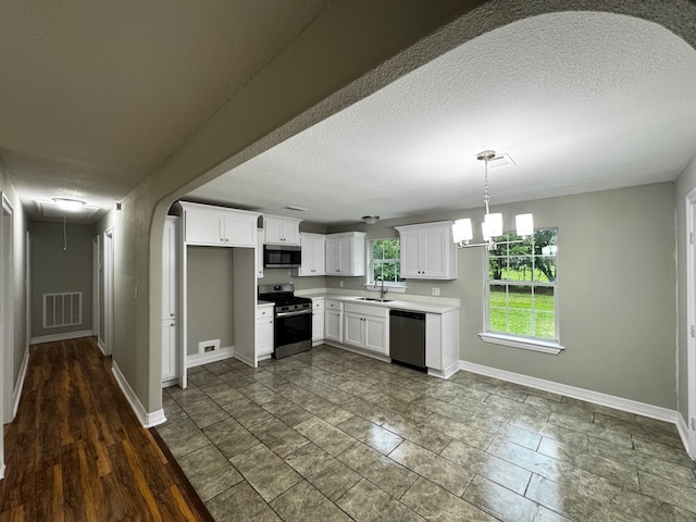 kitchen featuring a sink, a textured ceiling, stainless steel appliances, baseboards, and visible vents