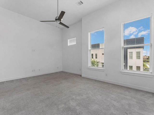 empty room with a ceiling fan, baseboards, visible vents, and light carpet