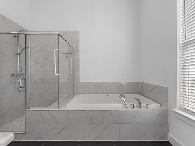 bathroom featuring a marble finish shower and a bath