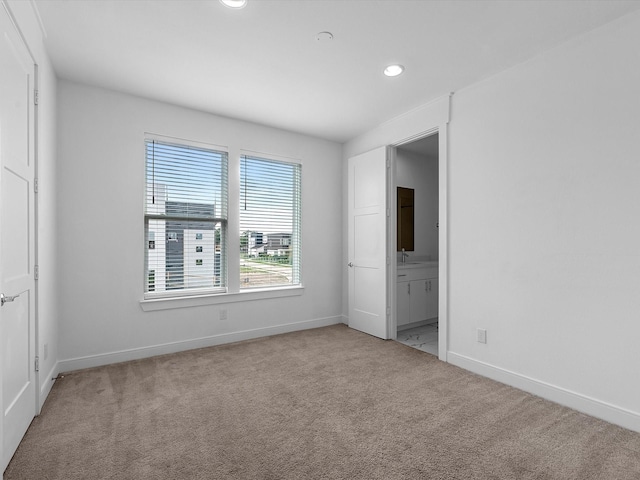 spare room featuring recessed lighting, baseboards, and light colored carpet