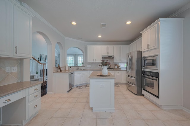 1307 Romero Dr, Pearland, TX 77581 - kitchen with a sink, tasteful backsplash, arched walkways, and appliances with stainless steel finishes