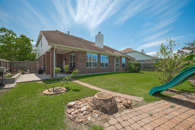 1307 Romero Dr, Pearland, TX 77581 - back of property featuring a chimney, brick siding, a patio, a playground, and a fenced backyard