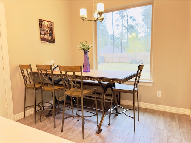 dining room with baseboards, wood finished floors, and a notable chandelier