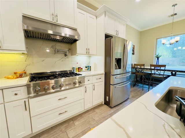 kitchen featuring appliances with stainless steel finishes, an inviting chandelier, decorative backsplash, under cabinet range hood, and visible vents