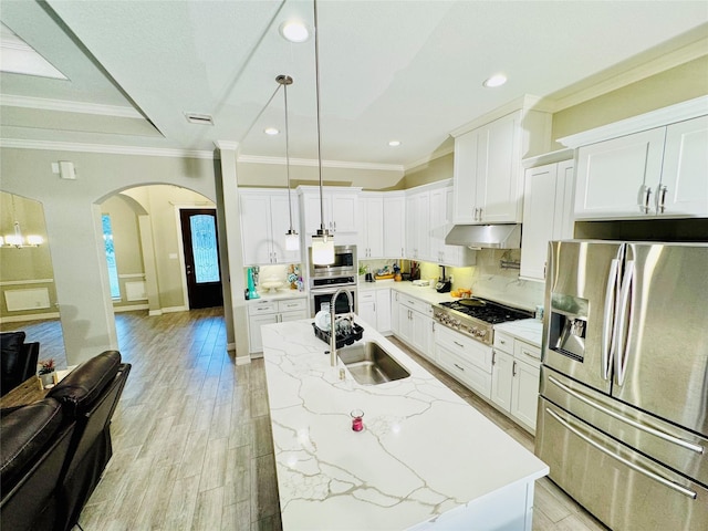 kitchen with visible vents, arched walkways, under cabinet range hood, a sink, and appliances with stainless steel finishes