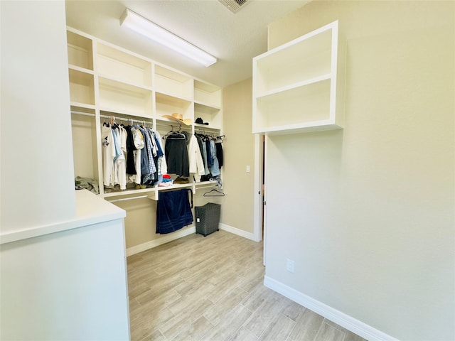 walk in closet with light wood-type flooring and visible vents