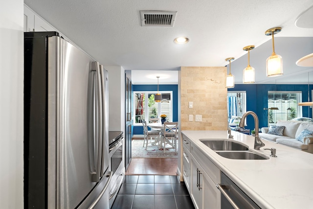 8944 Chatsworth Dr, Houston, TX 77024 - kitchen featuring white cabinets, stainless steel appliances, visible vents, and a sink
