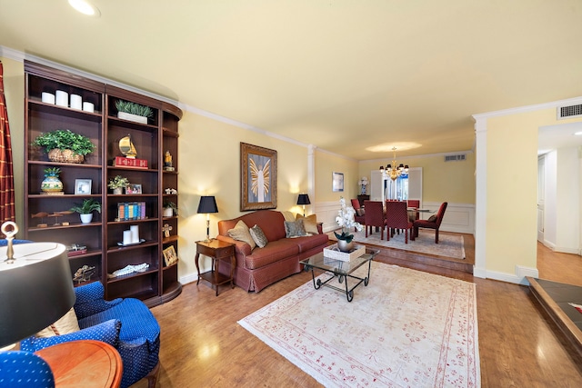 8944 Chatsworth Dr, Houston, TX 77024 - living room featuring visible vents, ornamental molding, wood finished floors, and an inviting chandelier
