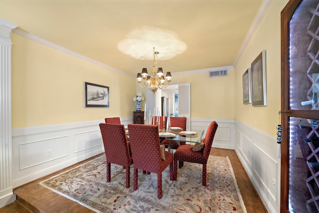8944 Chatsworth Dr, Houston, TX 77024 - dining space featuring crown molding, wainscoting, wood finished floors, a chandelier, and a decorative wall