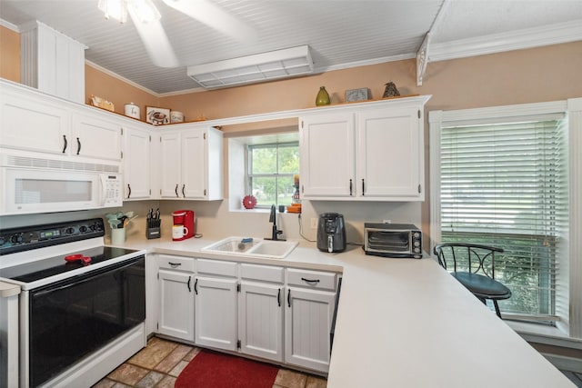kitchen with white microwave, light countertops, white cabinetry, a sink, and range with electric cooktop