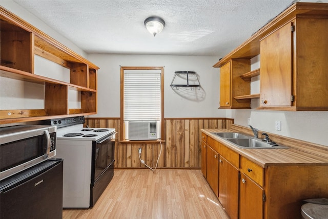 kitchen with electric range, open shelves, wainscoting, a sink, and stainless steel microwave