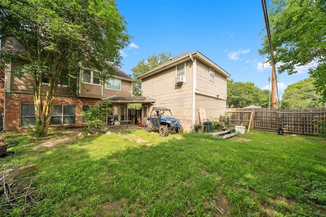 back of house with brick siding, a patio area, fence, and a yard