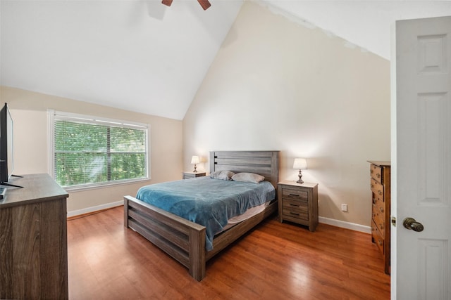 bedroom featuring a ceiling fan, baseboards, vaulted ceiling, and wood finished floors