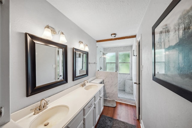 bathroom with a sink, a walk in shower, a textured ceiling, and wood finished floors