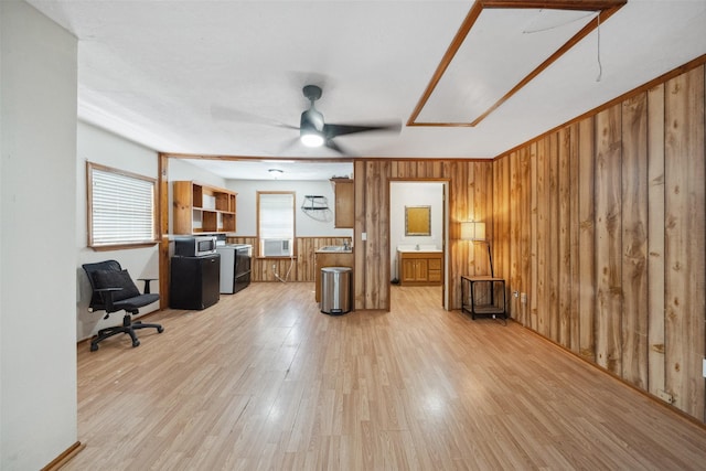 interior space featuring wood walls, light wood-style flooring, and ceiling fan