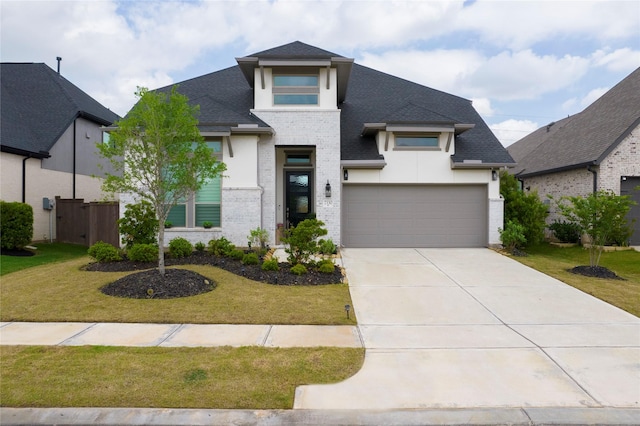 modern home with roof with shingles, an attached garage, brick siding, a front yard, and driveway
