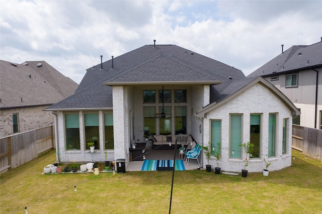 back of house with a lawn, a fenced backyard, a patio area, and an outdoor hangout area
