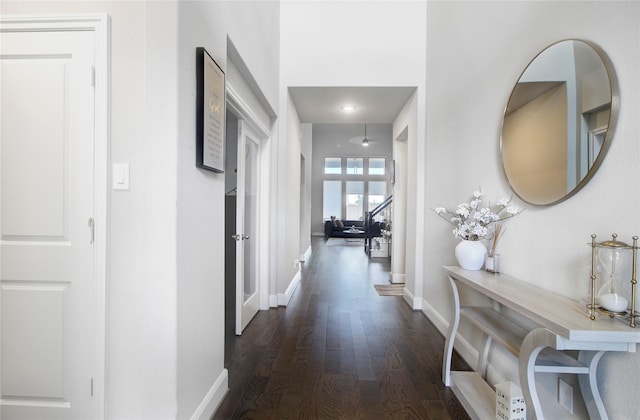 corridor with baseboards and wood finished floors