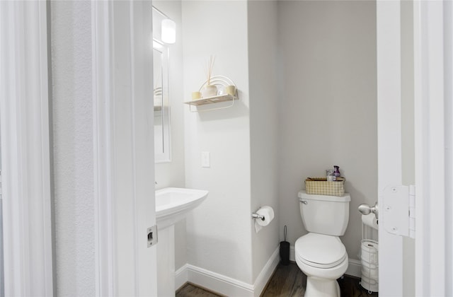 bathroom featuring baseboards, toilet, and wood finished floors