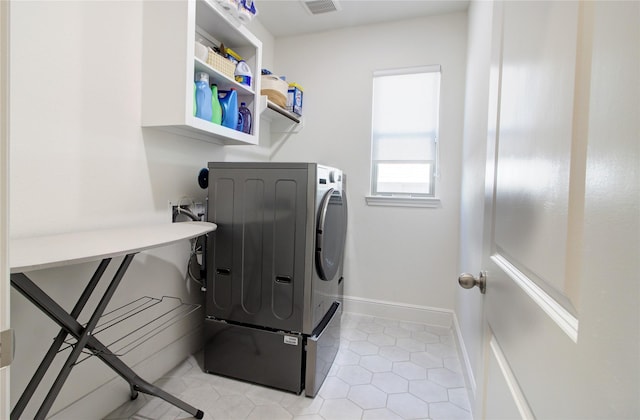 laundry area with laundry area, washer / clothes dryer, visible vents, baseboards, and light tile patterned flooring