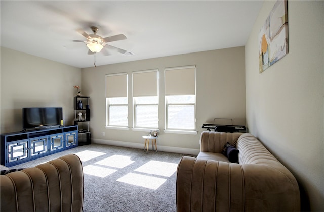 carpeted living room featuring ceiling fan and baseboards