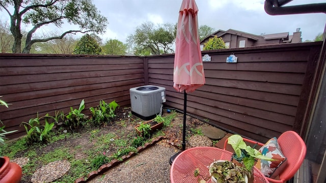 view of yard with central AC unit and a fenced backyard