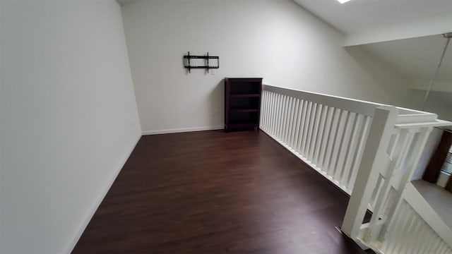 corridor with baseboards and wood finished floors