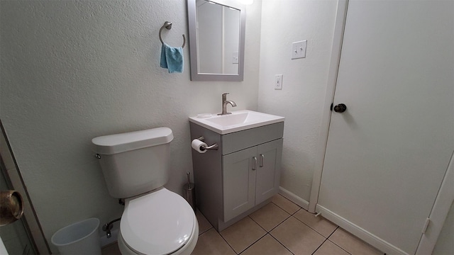 bathroom featuring vanity, tile patterned flooring, baseboards, and toilet