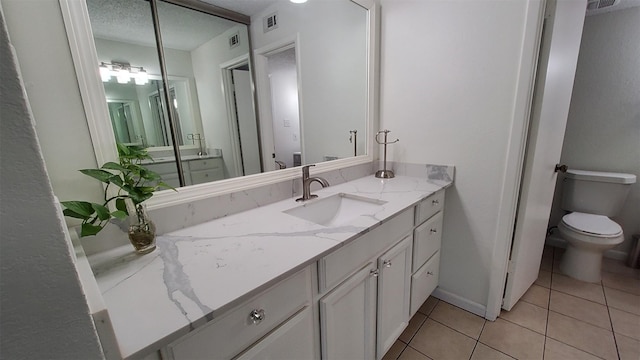 bathroom featuring vanity, tile patterned flooring, toilet, and visible vents