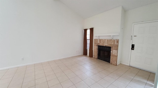 unfurnished living room with light tile patterned floors, high vaulted ceiling, baseboards, and a brick fireplace