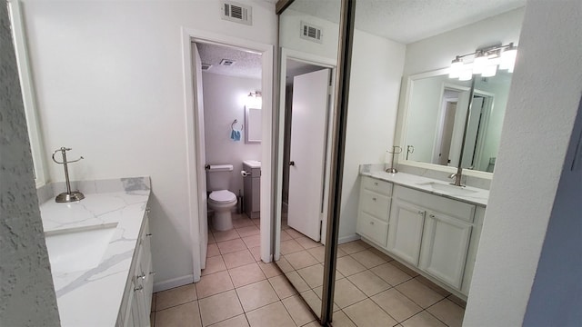 full bath featuring a textured ceiling, visible vents, tile patterned floors, and vanity
