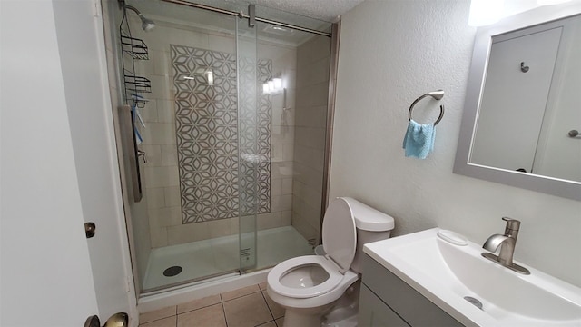 bathroom with a textured ceiling, a shower stall, vanity, tile patterned floors, and toilet