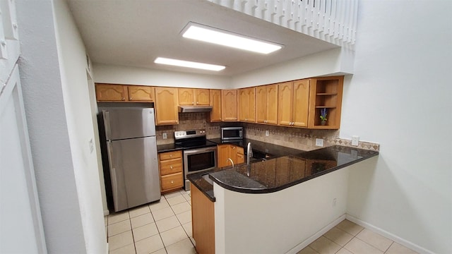 kitchen featuring under cabinet range hood, light tile patterned flooring, appliances with stainless steel finishes, and tasteful backsplash
