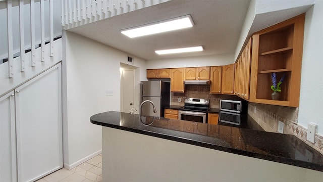 kitchen with visible vents, tasteful backsplash, a peninsula, under cabinet range hood, and stainless steel appliances