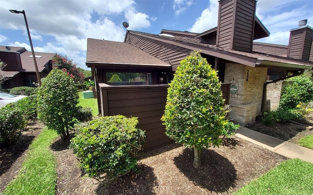 2611 Grants Lake Blvd Unit 228, Sugar Land, TX 77479 - view of property exterior with a chimney and roof with shingles