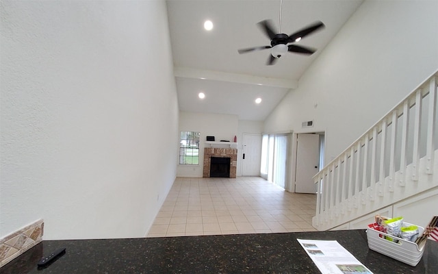 2611 Grants Lake Blvd Unit 228, Sugar Land, TX 77479 - unfurnished living room with stairway, tile patterned flooring, high vaulted ceiling, a ceiling fan, and a fireplace