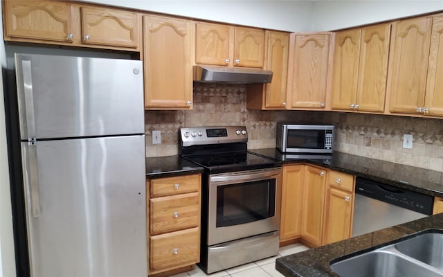 2611 Grants Lake Blvd Unit 228, Sugar Land, TX 77479 - kitchen with stainless steel appliances, under cabinet range hood, dark stone counters, and decorative backsplash