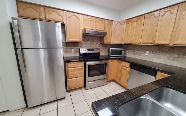 2611 Grants Lake Blvd Unit 228, Sugar Land, TX 77479 - kitchen featuring stainless steel appliances, under cabinet range hood, light tile patterned flooring, dark stone countertops, and backsplash