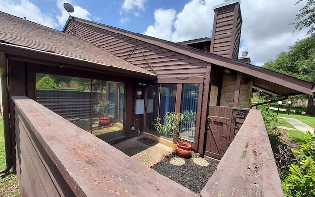 2611 Grants Lake Blvd Unit 228, Sugar Land, TX 77479 - view of exterior entry featuring a chimney and roof with shingles