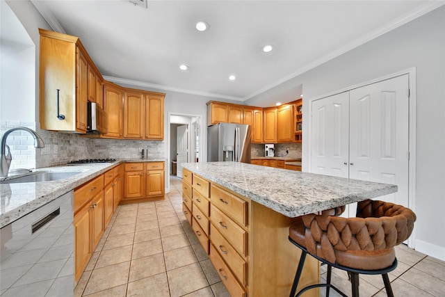 kitchen with backsplash, a center island, a sink, ornamental molding, and stainless steel appliances
