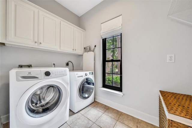 washroom with baseboards, cabinet space, independent washer and dryer, and light tile patterned floors