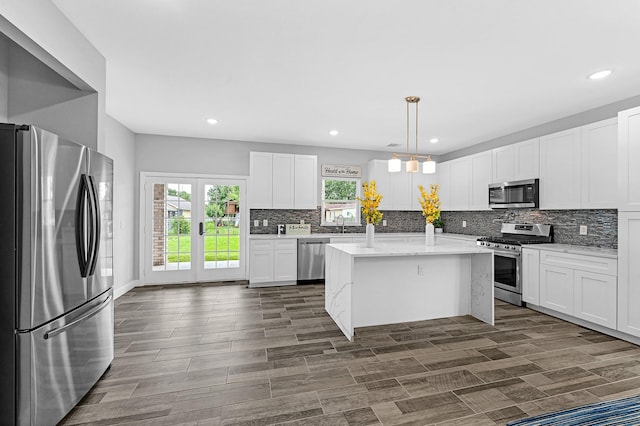 3409 2nd Ave N, Texas City, TX 77590 - kitchen featuring appliances with stainless steel finishes, a center island, recessed lighting, white cabinetry, and tasteful backsplash