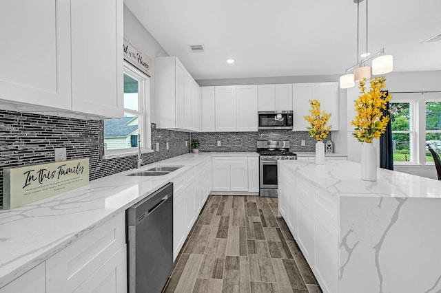 3409 2nd Ave N, Texas City, TX 77590 - kitchen with a sink, white cabinetry, appliances with stainless steel finishes, and a wealth of natural light